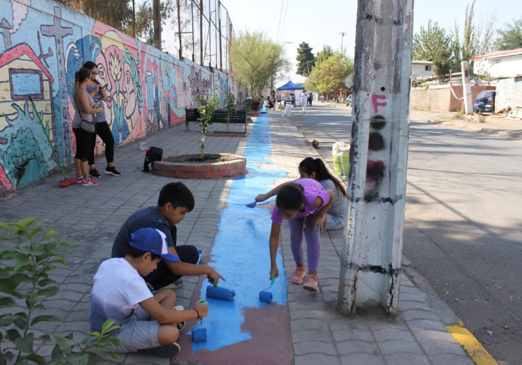 Foto de grupo de niños pintando el piso color celeste