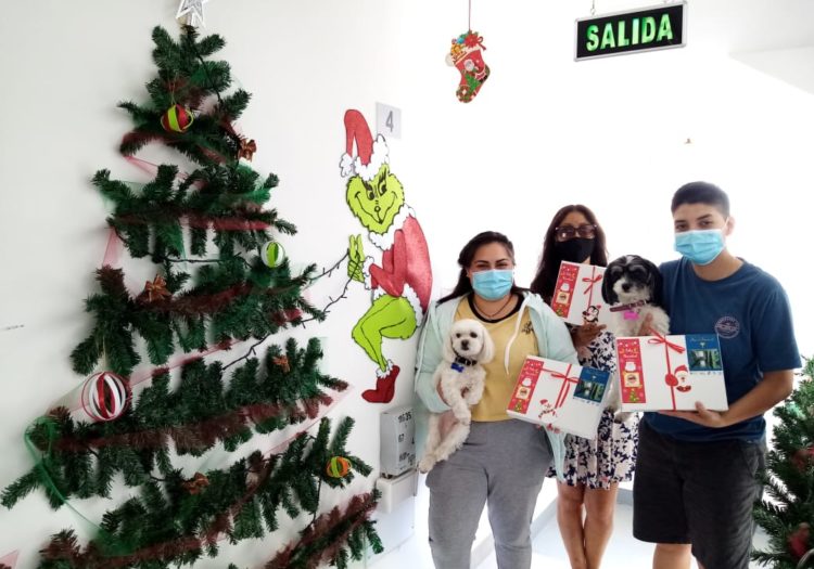 Foto de Arbol de navidad y personas mostrando sus regalos
